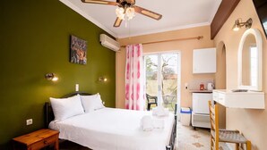 A bedroom with a bed, bedside table, ceiling fan, air conditioning unit, and a view of the outside. - Southgate 4 by MPS (Agios Georgios)