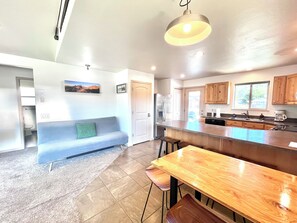 A modern kitchen with a central island, wooden cabinets, and a built-in oven. - Downtown Ennis Madison River Tranquil Guest House (Ennis)