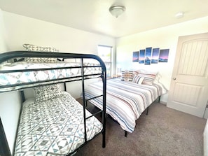 Een kamer met stapelbedden, een deur en wanddecoratie.