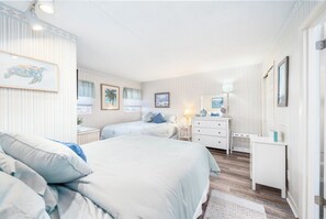 A bedroom with two beds, a dresser, and a nightstand. - 5th Floor Oceanfront Condo w/ Outdoor Pool by Seaside Vacations & Sales (Ocean City)