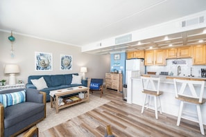 A modern kitchen with wooden cabinets and a bar area. - 5th Floor Oceanfront Condo w/ Outdoor Pool by Seaside Vacations & Sales (Ocean City)