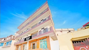 Een meerlaags hotel met balkons, een trap en een bord waarop staat dat het een hotel is.