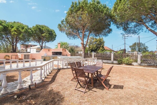 An outdoor patio with a table and chairs, surrounded by a white balustrade.