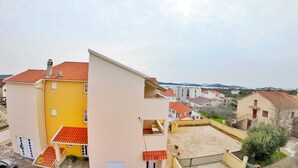 Ett bostadsområde med olika byggnader, bland annat en gul byggnad med rött tak och en vit byggnad med rött tak.