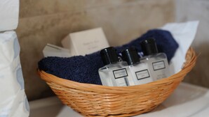 A wicker basket containing two bottles of Beekman cologne and a beige box.
