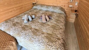 A wooden room with a bed, a small table, and an air conditioning unit. - Feudo Mallav b&b Noto (Avola)