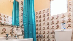 Un bagno con lavandino, WC e tenda da doccia.
