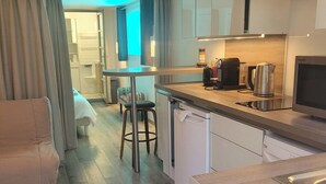 Une cuisine moderne avec un coin repas, un canapé et une vue sur le salon.