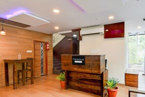 A reception desk labeled 'Townhouse' with a wooden interior, a staircase, and potted plants.