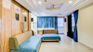 A corridor with two beds, a ceiling fan, and a sign indicating CCTV surveillance. - Deluxeshanthaa Residency (Hyderabad)