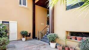 A paved courtyard with potted plants, a staircase, and a door. - Deluxe Amritsar District Court (Amritsar)