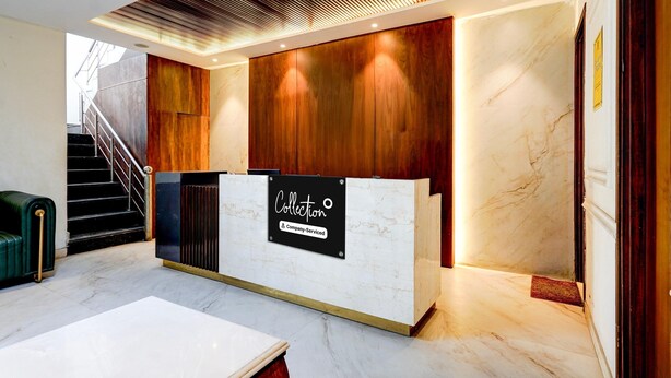 A reception desk with a sign, a staircase, and a marble floor. - Deluxe Amritsar District Court (Amritsar)