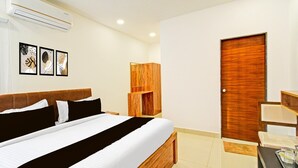 Ein Hotelzimmer mit Bett, einem Holzschrank, einer Tür und Wandbildern.