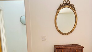 A room with a light green dresser, a wicker basket on top, and a gold-framed mirror on the wall. - Central Hove near beach & lawns (Brighton and Hove)