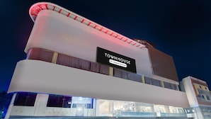A modern building with a sign reading 'TOWNHOUSE.' - Deluxehotel Surabhi Elite (Hyderabad)