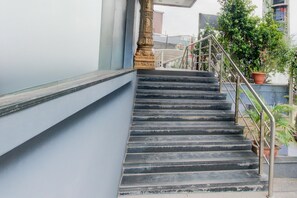 Eine Treppe mit Metallgeländern, einer blauen Wand und einem Blumentopf.