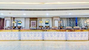 A reception area with a counter, decorative lamps, and a patterned wall. - Deluxehotel Surabhi Elite (Hyderabad)