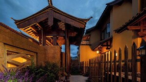 A traditional building with a wooden structure, a stone wall, and a pathway. - Aofeng Tangquan Secluded Villa (Dali)