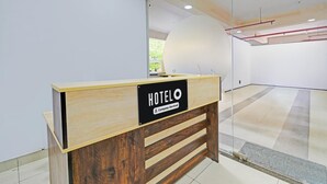 Un mostrador de recepción con un cartel que dice 'HOTELO' y un símbolo de servicio de la empresa.