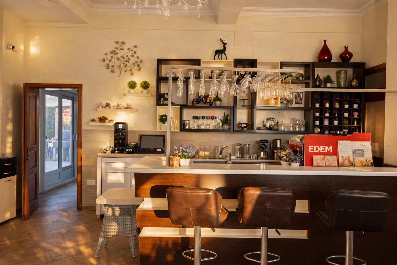 A modern kitchen with a bar area, bar stools, and a countertop with various items.