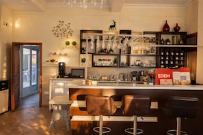 A modern kitchen with a bar area, bar stools, and a countertop with various items.
