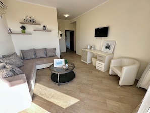 A living room with a sofa, coffee table, and a desk with drawers.