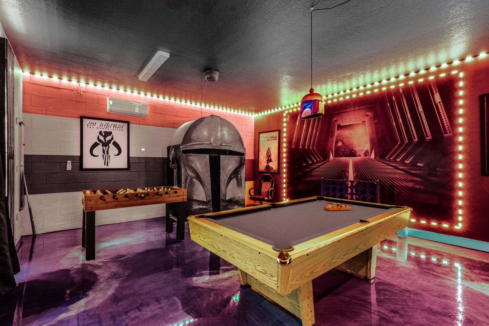 A pool table, a foosball table, and a Star Wars-themed wall.