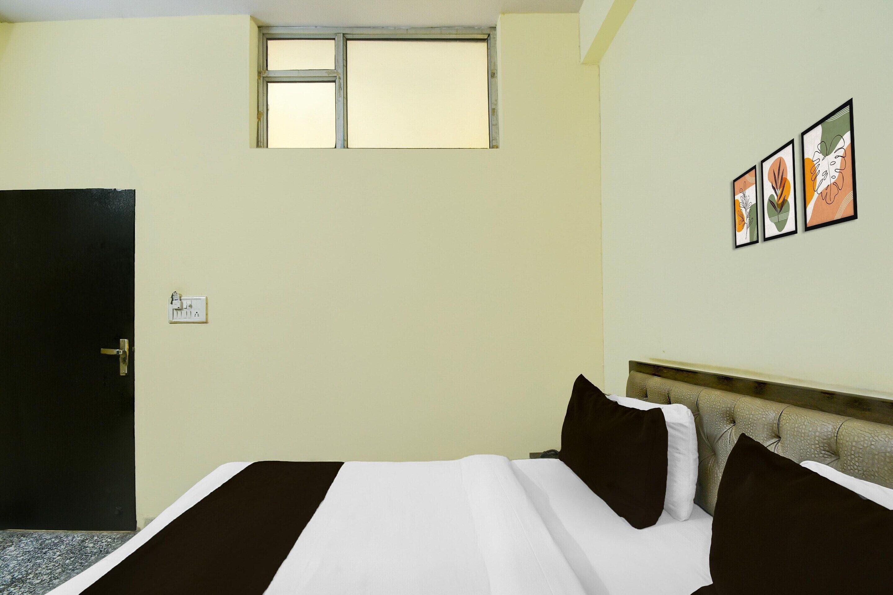 Una camera d'albergo con un letto, una finestra e una porta.