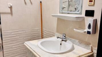 Een douche, handdoeken, zeep, toiletpapier