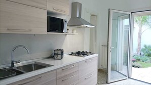 Una cocina moderna con pileta, tostadora, microondas y estufa a gas.