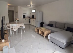 Ein moderner Wohnbereich mit Essbereich, einer Couch und einer Küche.