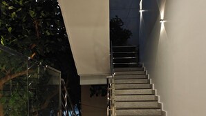 A modern staircase with a marble floor leading to a dark interior. - AKSHAYA COMFORTS (Visakhapatnam)