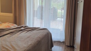 A bedroom with a bed, a window with curtains, and a view of the outdoors. - By trails and parks, near cafés, 25 min from Energylandia. (Bielsko-Biała)