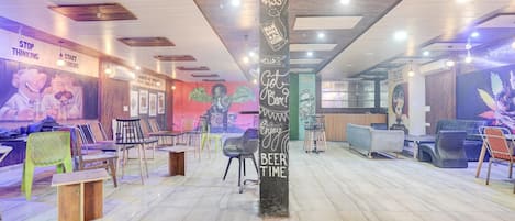 A modern interior with a central pillar, seating areas, and artwork on the walls.