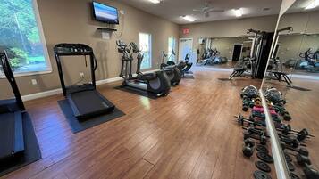 A gym with treadmills, elliptical machines, and free weights.