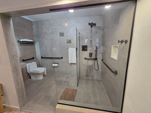 Un baño moderno con ducha de vidrio, inodoro y lavamanos.