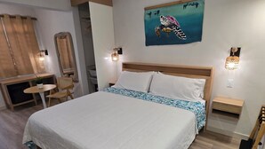 A bedroom with a large bed, bedside tables, a chair, a desk, and a wall painting. - King-Bed Room Accessible in Stella, Rincón - right on the beach (Rincón)