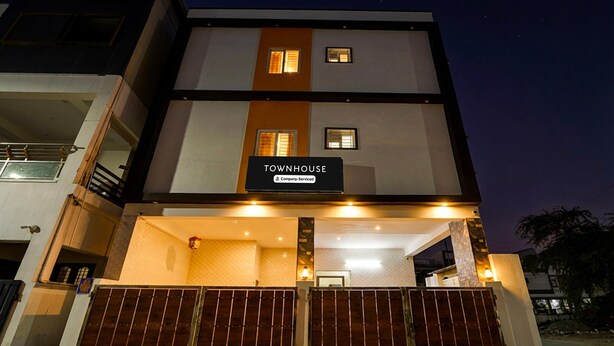 Ein mehrstöckiges Gebäude mit einem Schild, auf dem 'TOWNHOUSE' steht, und einem verschlossenen Eingang.