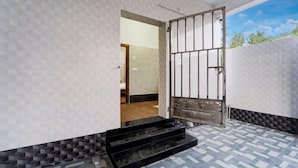 Ein moderner Eingangsbereich mit einer Wand im geometrischen Muster, einem Metallgitter und einem gefliesten Boden.
