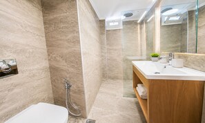 A modern bathroom with a bathtub, a shower, a vanity with a mirror, and a potted plant. - Art Apartment | 80m from the Beach with Balcony & Private Parking (Palaiochora)