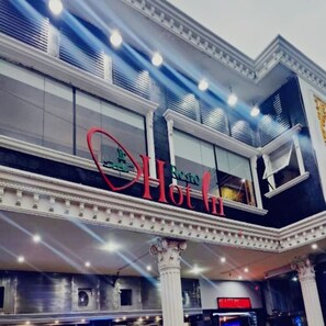 A hotel exterior with a prominent sign reading 'Hot Inn.' - Hot In Hotel (Depok)