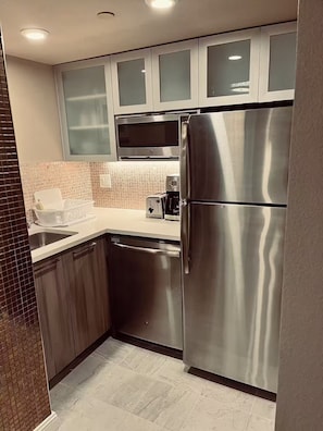 A modern kitchen with stainless steel appliances, a microwave, and a coffee maker.