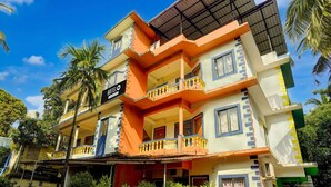 A multi-story hotel with a prominent 'HOTEL' sign, balconies, and a gated entrance. - Deluxecrystal Holiday Homes (Calangute)