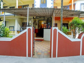 A building entrance with a covered walkway, a checkered floor, and a gated entrance.