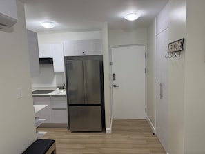 A compact kitchen with white cabinets, a stainless steel refrigerator, and a 'WELCOME' sign on the wall. - Spacious 3-bedroom apartment with AC in superb San Rafael (San Rafael)
