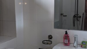 A bathroom with a toilet, sink, and shower. - Kay's Place Cultural Apartment Zanzibar Gallery (Zanzibar)