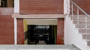 A building entrance with a metal staircase and a closed shutter door. - Deluxeamba Palace (Prayagraj)