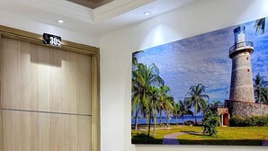 A hotel room with a wooden door, a number sign above it, and a wall-mounted painting of a lighthouse. - HOTEL LA ESTRELLA DE DAVID  (Cartagena)