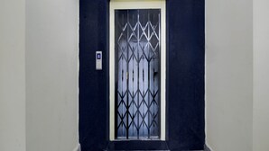 A door with a metal security grille and a light switch on the wall beside it. - Deluxecollection O Kothapet Near Omini Hospital (Hyderabad)