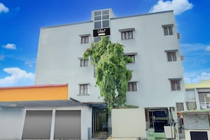A multi-story building with a sign indicating a collection service. - Deluxecollection O Kothapet (Hyderabad)